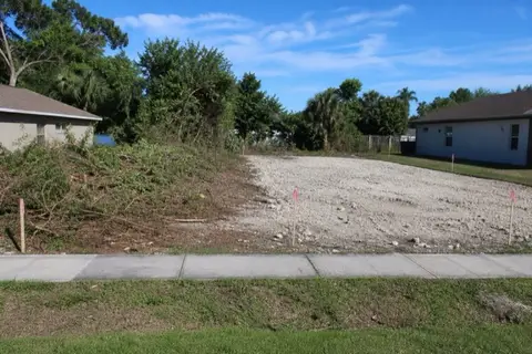 Half-cleared infill lot in Pembroke Pines showing pale limerock pad beside remaining Brazilian pepper thicket